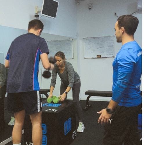 David Parra entrenando a una clienta con mancuernas